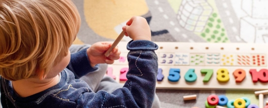 toddler boy at daycare playing with toys